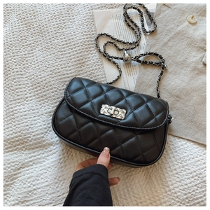 Detail of black quilted leather bag with silver metallic twist lock and chain strap