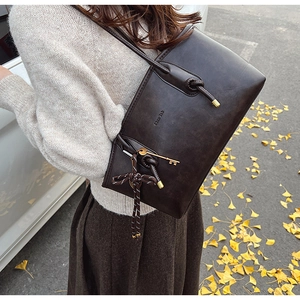 Dettaglio borsa tote marrone vintage con texture pelle e nodo in corda intrecciata laterale