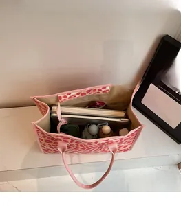 Top view showing large storage capacity of pink leopard print tote bag with daily items