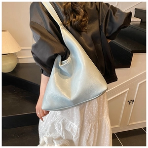 Close-up of light blue hobo bag with textured crinkle leather on a female model
