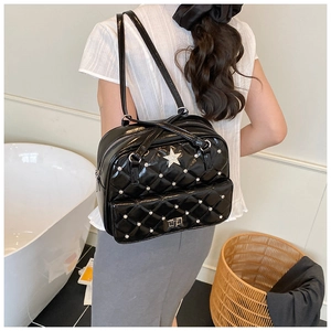 Detail of black quilted leather backpack with silver star studs and rivets on the pocket
