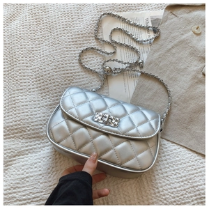 Detailed view of silver quilted crossbody bag with metal chain strap and turn-lock closure