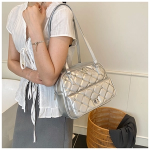 Close-up of silver diamond-quilted shoulder bag with star buckle and rhinestone details