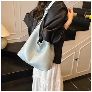 Detail of light blue faux leather tote bag showing soft texture and adjustable strap