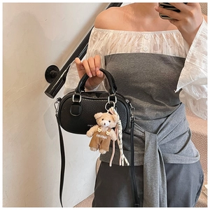 Detail of black lychee grain bowling bag with cute teddy bear charm and strap