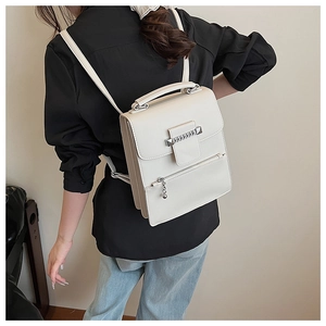 Modellansicht des cremefarbenen Lederrucksacks mit Metallkette und modischen Trägern