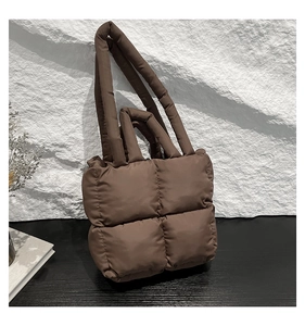 Nahaufnahme der braunen gesteppten Daunen-Tote-Bag mit dicken Griffen und Textur