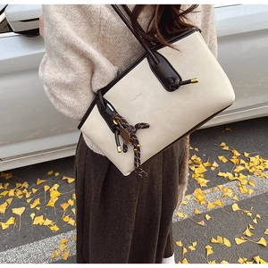Elegante borsa tote beige con finiture marroni in un servizio fotografico street style