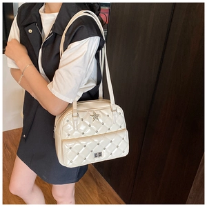 Close-up of white quilted patent leather bag with silver star and metal buckle