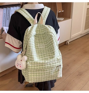 Side view of student checkerboard backpack with plush rabbit and logo embroidery