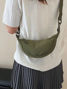 Olive green nylon half-moon crossbody bag with decorative plastic chain and textile strap