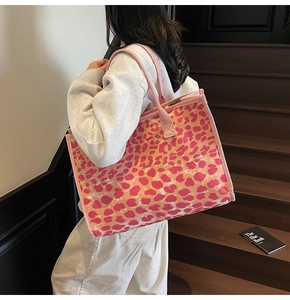 Detail of pink leopard print tote bag showing canvas texture and reinforced shoulder strap