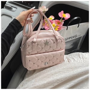 Close-up of pink quilted tote bag with silver stars, rivets, and twist-lock detail