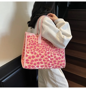 Detailed view of pink leopard print tote bag being carried by a model on stairs