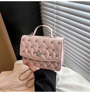 Macro detail of pink quilted faux leather bag with crystal star and rivet decoration