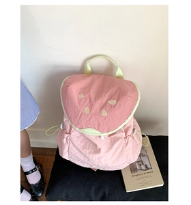 Detailed view of pink watermelon backpack with yellow seed embroidery and drawstring sides
