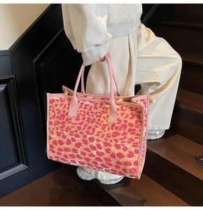 Detailed side view of large canvas tote bag with pink and orange leopard print