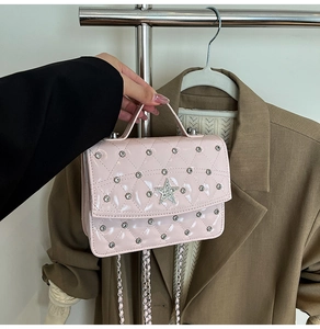 Close-up of pink patent leather quilted bag with silver rivets and star diamond detail