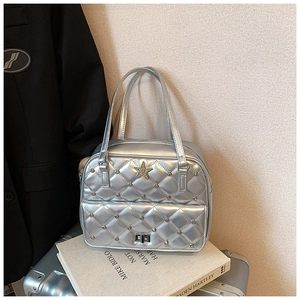 Macro detail of silver quilted tote bag with sequin star and metal rivet accents