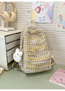 Detail of yellow and purple plaid backpack with white floral print and plush bunny charm
