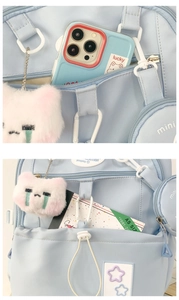 Détail du sac à dos en nylon bleu clair avec écusson étoile et porte-clé chat en peluche