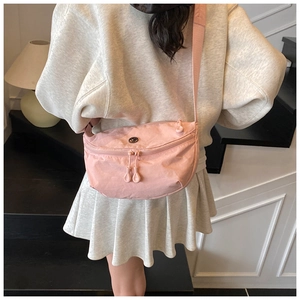 Detailed close-up of a pink nylon crescent crossbody bag with double zipper and wide strap
