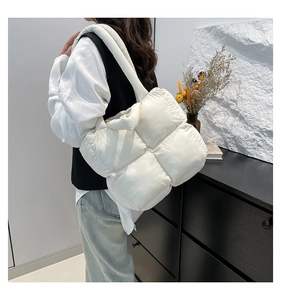 Weiße gesteppte Puffer-Tasche am Modell für Größen- und Texturdetails gezeigt