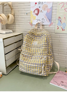 Detail of yellow and purple plaid backpack with zippered pocket and side bottle holder