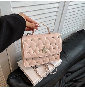 Close-up of pink quilted leather bag with silver studs and a large crystal star detail
