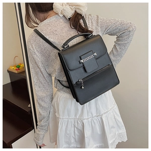 Detailansicht eines schwarzen Kunstlederrucksacks mit Silberkette und Nietenbesatz