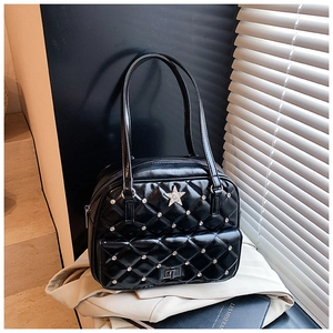 Detail of black quilted shoulder bag featuring star ornament and metal turn-lock pocket