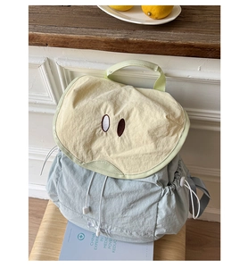 Detail of light blue backpack with apple embroidery and adjustable drawstring closure