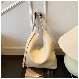Close-up of off-white faux leather hobo bag with textured grain and silver metal buckle
