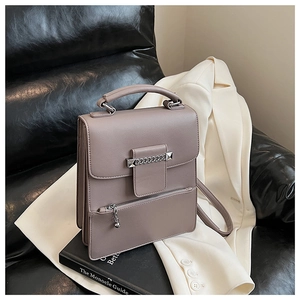 Details der grau-violetten Lederhandtasche mit Metallkette und Kugel-Reißverschluss