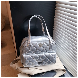 Close-up of silver quilted tote bag with star ornament and metal stud details