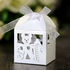 Close-up of laser-cut baby shower candy box with hollow bear and heart patterns