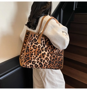 Rear view of a model wearing the large leopard print tote bag on stairs in daily style