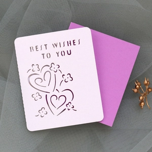 Detail of laser-cut heart greeting card with Best Wishes text and purple envelope