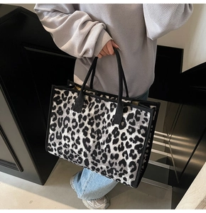 Detailed view of large leopard print tote bag with black handles and knit texture