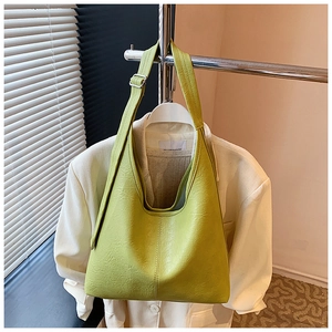 Detail of light green leather bucket bag with adjustable shoulder strap and silver hardware