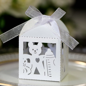 Detail of white laser-cut bear and bottle candy box with elegant silver ribbon bow