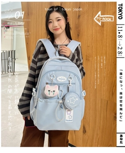 Close-up of light blue waterproof backpack featuring multiple pockets and cute accessories