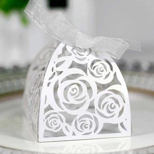 Detail of white laser-cut rose gift box with a silver ribbon bow for wedding favors