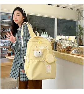 Detail view of water-resistant light yellow backpack with cute bear and star accessories