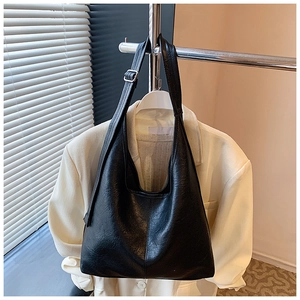 Detail of black large bucket bag with adjustable wide strap and silver metal buckle