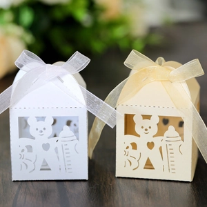 Detailed view of laser-cut bear and baby bottle gift boxes with pearlescent finish and ribbons