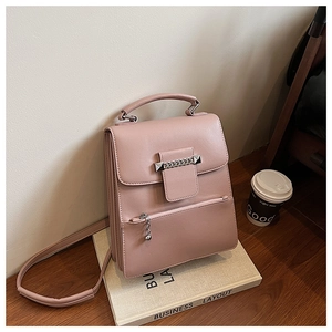 Detailansicht der rosa PU-Handtasche mit Silberkette und Nieten auf einem Schreibtisch