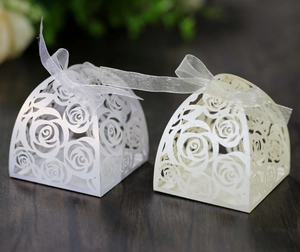 Detail of laser-cut rose gift boxes with satin ribbons for weddings and parties