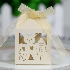 Macro detail of laser-cut paper gift box featuring a cute bear and baby bottle design