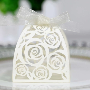 Detailed view of white laser-cut rose candy box with elegant sheer ribbon and floral hollows